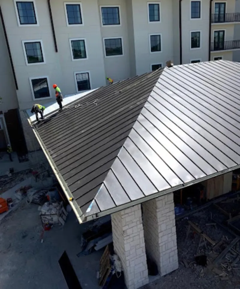 Crew installing standing seam metal roof panels on a commercial project in Lemon Grove